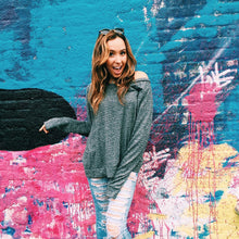 Load image into Gallery viewer, Front of Cozy Comfy Crewneck (grey crewneck), worn on a 20-year-old standing in front of a colorful wall. 