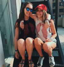 Load image into Gallery viewer, Two girls wearing ANGELIC NYC. One has a black tank with red wings and the other wearing a white tank with red wings. 