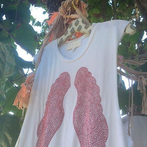 White Tank with Red Wings hanging on a tree. 