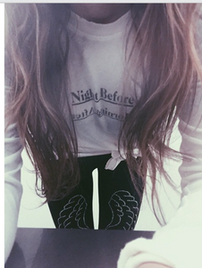 Girl wearing legwings. Black leggings with black and silver wings on each leg. 