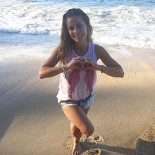 Load image into Gallery viewer, Influencer and wellness-guru Sophie Jaffe, in our Sweetheart Tank (baby pink tank top with red wings on the front), while enjoying a beautiful day on the beaches in Mexico. 