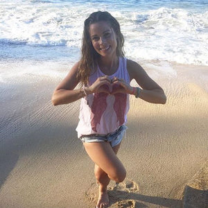 Influencer and wellness-guru Sophie Jaffe, in our Sweetheart Tank (baby pink tank top with red wings on the front), while enjoying a beautiful day on the beaches in Mexico. 